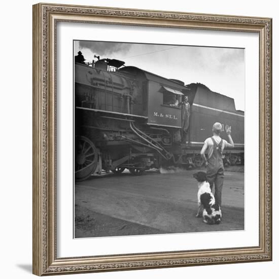 Young Boy and His Dog Standing at the Crossing as a Train Rides Through-Myron Davis-Framed Photographic Print