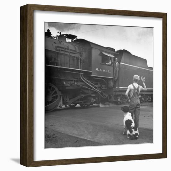 Young Boy and His Dog Standing at the Crossing as a Train Rides Through-Myron Davis-Framed Photographic Print