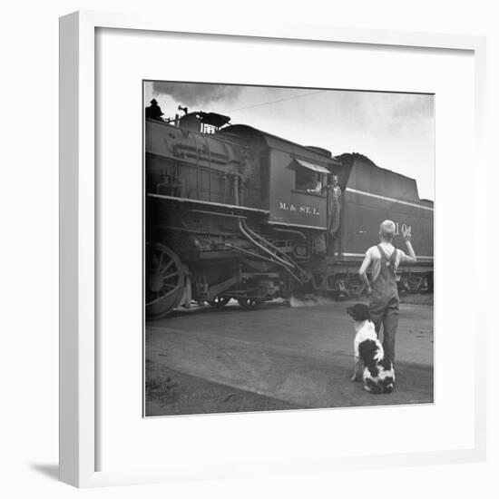 Young Boy and His Dog Standing at the Crossing as a Train Rides Through-Myron Davis-Framed Photographic Print