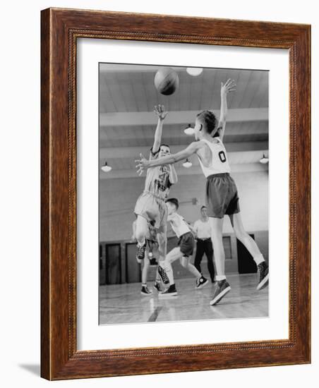 Young Boy Shooting a Free-Throw Shot over the Head of Another Young Boy-null-Framed Photographic Print