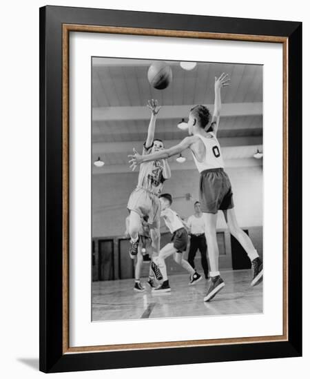 Young Boy Shooting a Free-Throw Shot over the Head of Another Young Boy-null-Framed Photographic Print