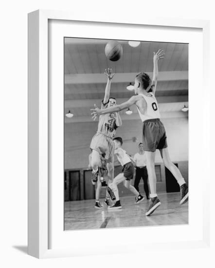 Young Boy Shooting a Free-Throw Shot over the Head of Another Young Boy-null-Framed Photographic Print