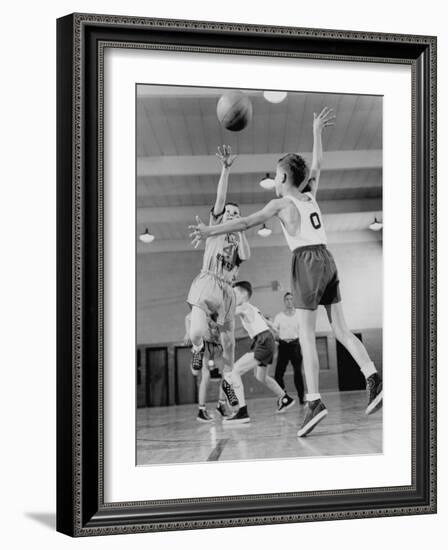 Young Boy Shooting a Free-Throw Shot over the Head of Another Young Boy-null-Framed Photographic Print