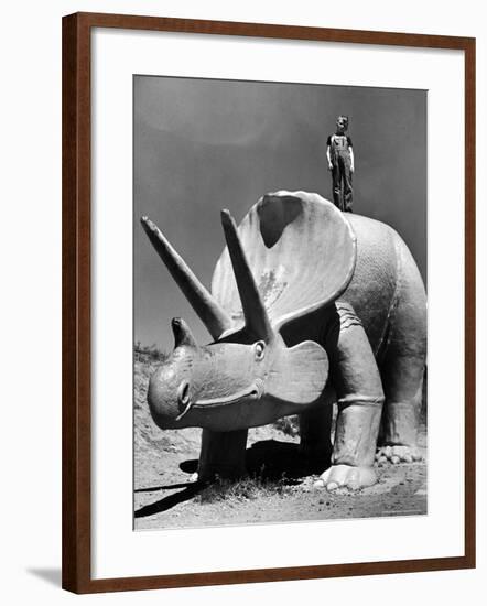 Young Boy Standing Atop Large Statue of Dinosaur in "Dinosaur Park" Tourist Attraction-Alfred Eisenstaedt-Framed Photographic Print