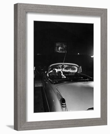 Young Couple Cuddling as They Watch a Movie at Drive in Theater-Francis Miller-Framed Photographic Print