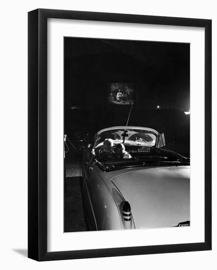 Young Couple Cuddling as They Watch a Movie at Drive in Theater-Francis Miller-Framed Photographic Print