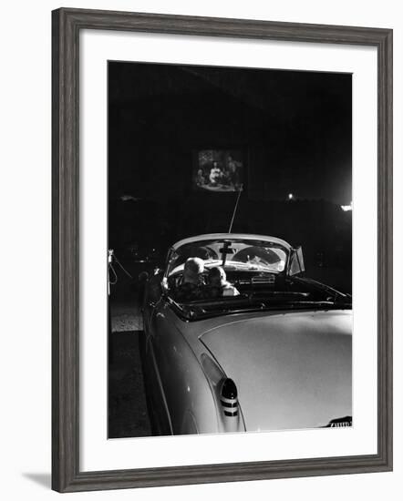 Young Couple Cuddling as They Watch a Movie at Drive in Theater-Francis Miller-Framed Photographic Print