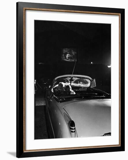 Young Couple Cuddling as They Watch a Movie at Drive in Theater-Francis Miller-Framed Photographic Print