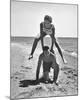 Young Couple Playing Leapfrog on the Beach-The Chelsea Collection-Mounted Giclee Print