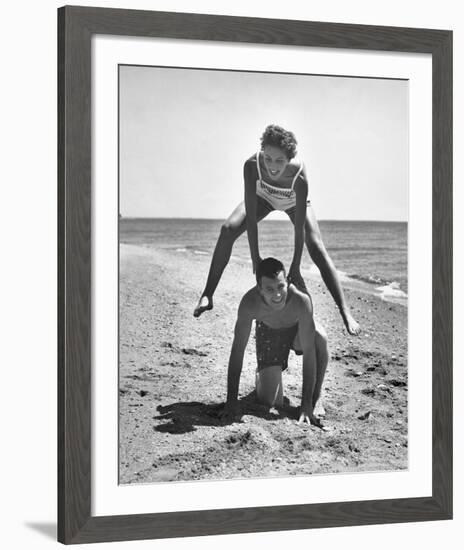 Young Couple Playing Leapfrog on the Beach-The Chelsea Collection-Framed Giclee Print