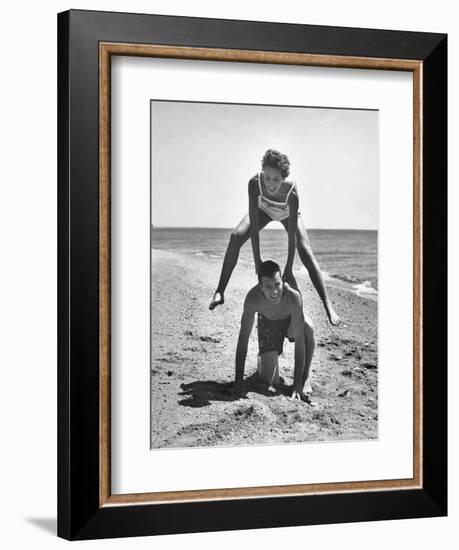 Young Couple Playing Leapfrog on the Beach-The Chelsea Collection-Framed Premium Giclee Print