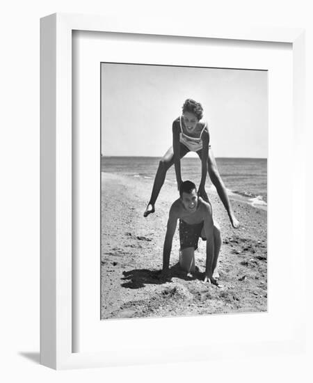 Young Couple Playing Leapfrog on the Beach-The Chelsea Collection-Framed Premium Giclee Print