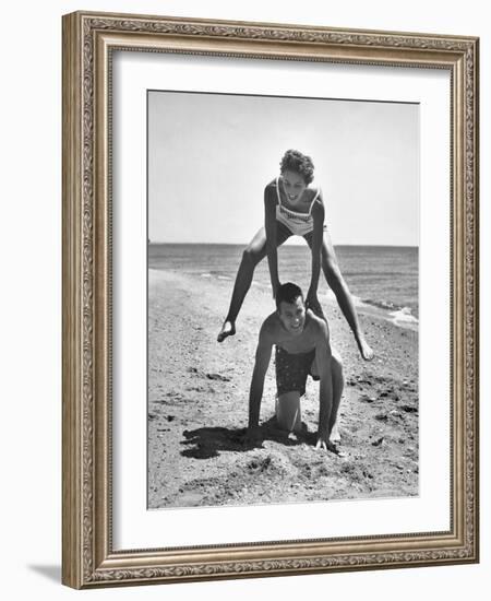 Young Couple Playing Leapfrog on the Beach-The Chelsea Collection-Framed Art Print