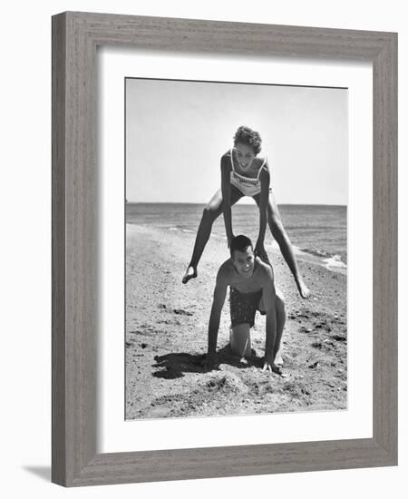 Young Couple Playing Leapfrog on the Beach-The Chelsea Collection-Framed Art Print