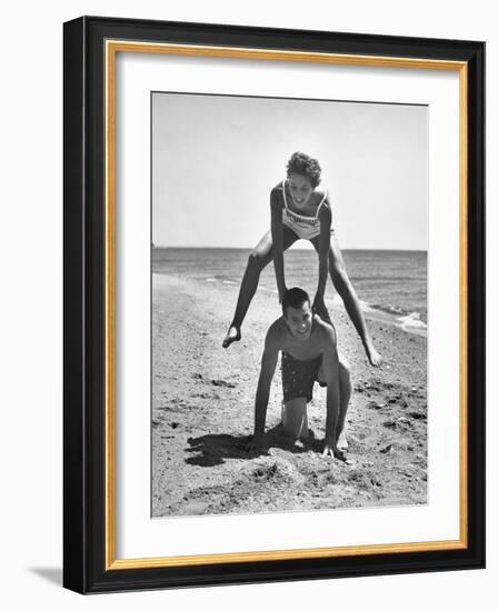 Young Couple Playing Leapfrog on the Beach-The Chelsea Collection-Framed Art Print