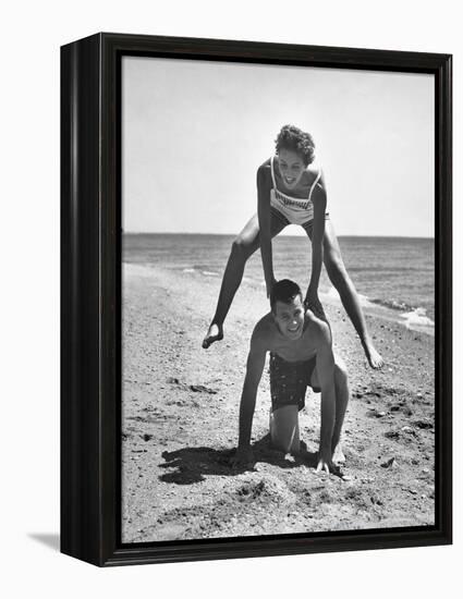 Young Couple Playing Leapfrog on the Beach-The Chelsea Collection-Framed Stretched Canvas
