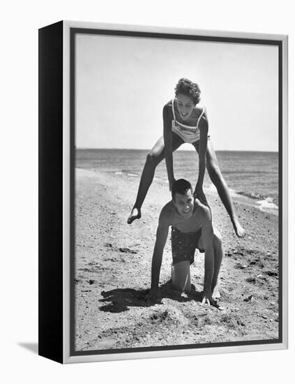 Young Couple Playing Leapfrog on the Beach-The Chelsea Collection-Framed Stretched Canvas