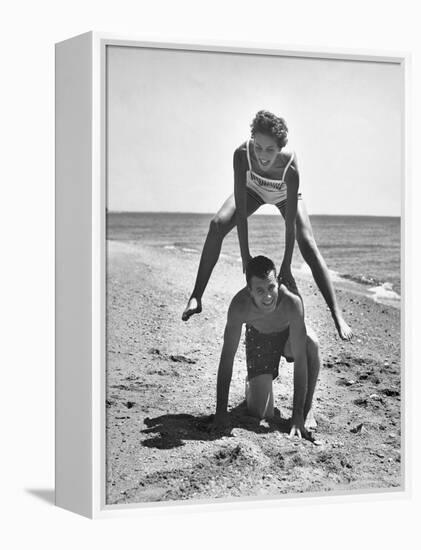 Young Couple Playing Leapfrog on the Beach-The Chelsea Collection-Framed Stretched Canvas