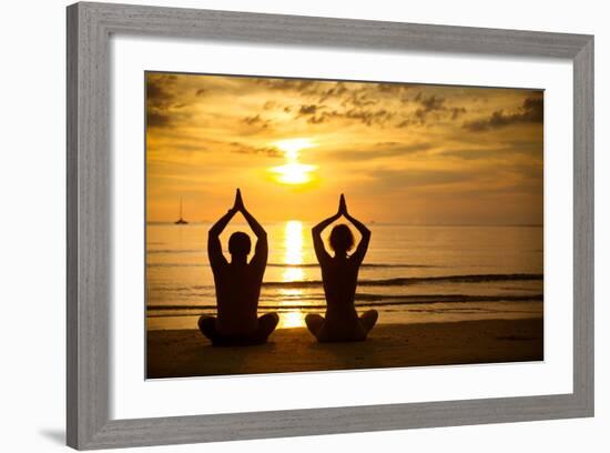 Young Couple Practicing Yoga On The Sea Beach At Sunset-De Visu-Framed Art Print