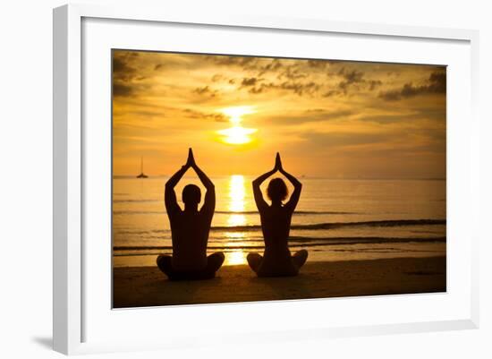 Young Couple Practicing Yoga On The Sea Beach At Sunset-De Visu-Framed Art Print