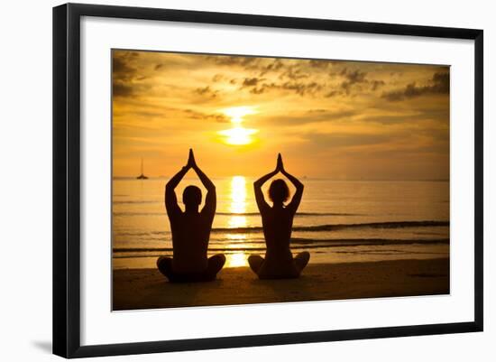 Young Couple Practicing Yoga On The Sea Beach At Sunset-De Visu-Framed Art Print