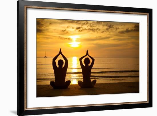 Young Couple Practicing Yoga On The Sea Beach At Sunset-De Visu-Framed Art Print