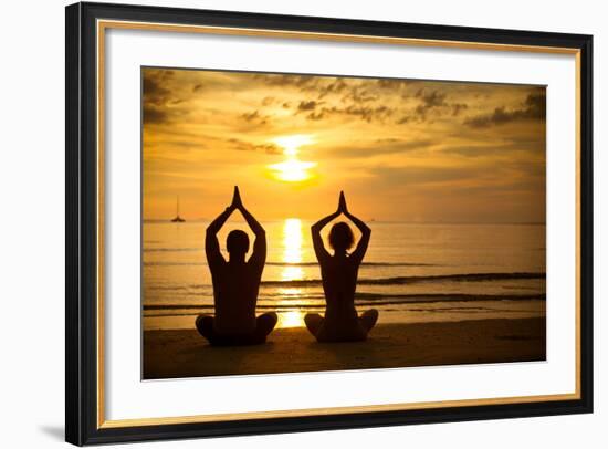 Young Couple Practicing Yoga On The Sea Beach At Sunset-De Visu-Framed Art Print