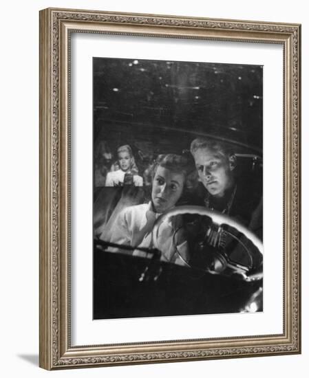 Young Couple Snuggling in Convertible as They Intently Watch Movie at Drive-in Movie Theater-J^ R^ Eyerman-Framed Photographic Print