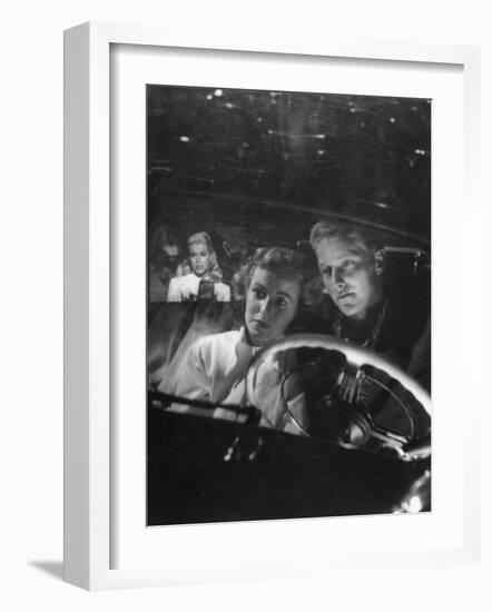 Young Couple Snuggling in Convertible as They Intently Watch Movie at Drive-in Movie Theater-J^ R^ Eyerman-Framed Photographic Print