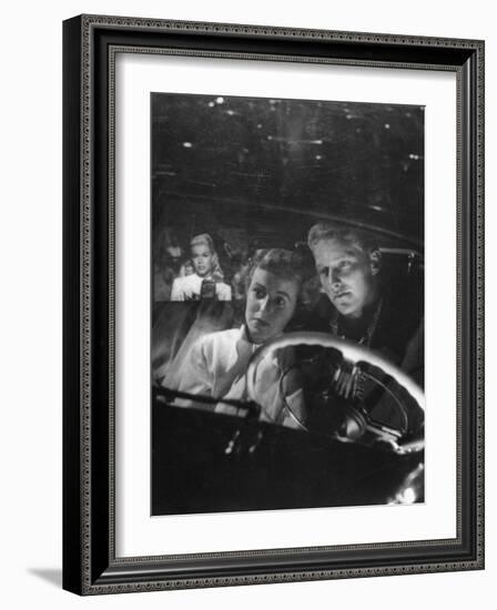 Young Couple Snuggling in Convertible as They Intently Watch Movie at Drive-in Movie Theater-J^ R^ Eyerman-Framed Photographic Print