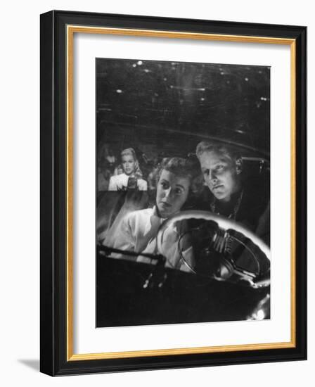 Young Couple Snuggling in Convertible as They Intently Watch Movie at Drive-in Movie Theater-J^ R^ Eyerman-Framed Photographic Print