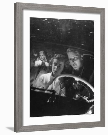 Young Couple Snuggling in Convertible as They Intently Watch Movie at Drive-in Movie Theater-J^ R^ Eyerman-Framed Photographic Print