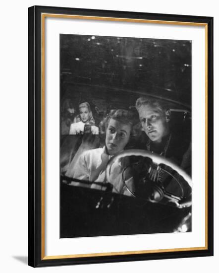 Young Couple Snuggling in Convertible as They Intently Watch Movie at Drive-in Movie Theater-J^ R^ Eyerman-Framed Photographic Print