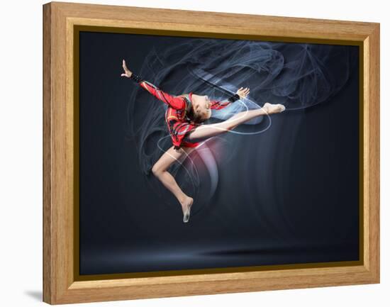 Young Cute Woman In Gymnast Suit Show Athletic Skill On Black Background-Sergey Nivens-Framed Stretched Canvas