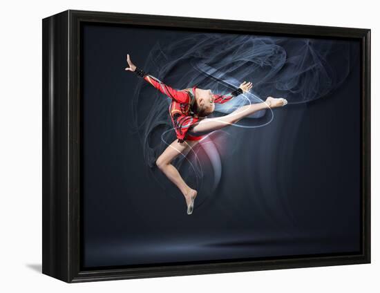 Young Cute Woman In Gymnast Suit Show Athletic Skill On Black Background-Sergey Nivens-Framed Stretched Canvas