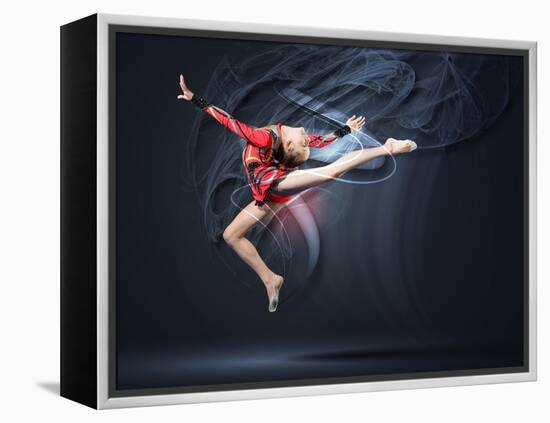 Young Cute Woman In Gymnast Suit Show Athletic Skill On Black Background-Sergey Nivens-Framed Stretched Canvas