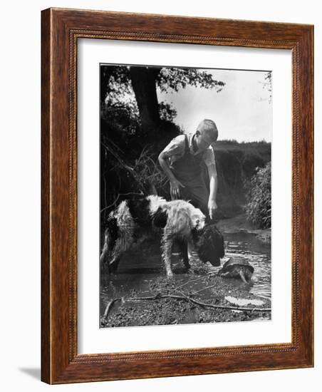 Young Farm Boy Watching His Dog Sniff a Large Turtle at the Pond-Myron Davis-Framed Photographic Print