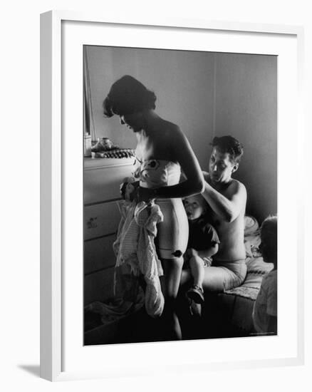 Young Father Helping His Wife Get Dressed as Their Sons Look On-Mark Kauffman-Framed Photographic Print