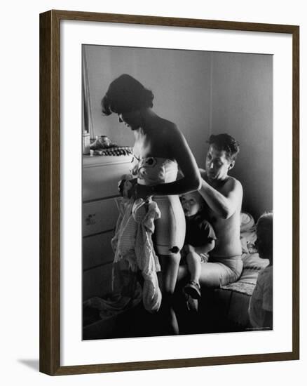 Young Father Helping His Wife Get Dressed as Their Sons Look On-Mark Kauffman-Framed Photographic Print