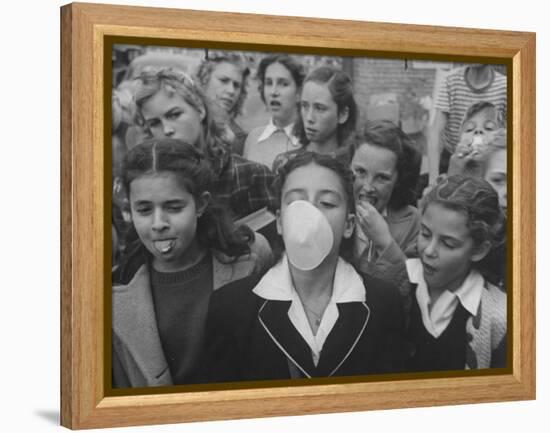 Young Girl Blowing a Bubble with Her Friends Watching-Bob Landry-Framed Premier Image Canvas