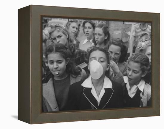 Young Girl Blowing a Bubble with Her Friends Watching-Bob Landry-Framed Premier Image Canvas