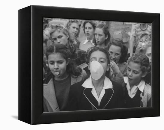 Young Girl Blowing a Bubble with Her Friends Watching-Bob Landry-Framed Premier Image Canvas