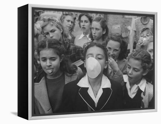 Young Girl Blowing a Bubble with Her Friends Watching-Bob Landry-Framed Premier Image Canvas