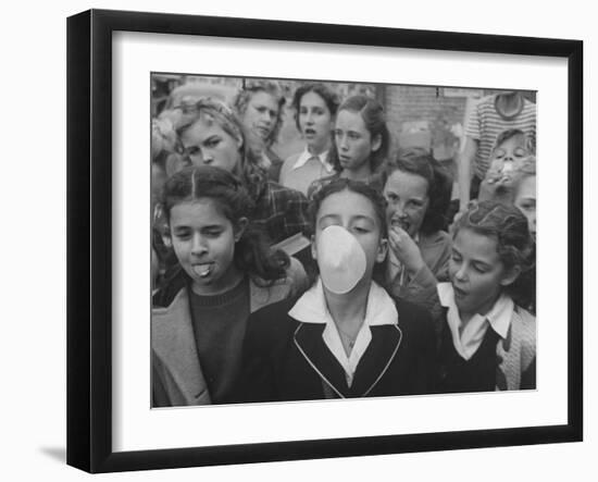 Young Girl Blowing a Bubble with Her Friends Watching-Bob Landry-Framed Photographic Print