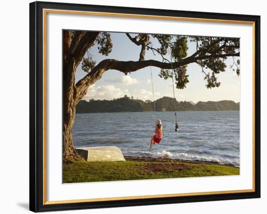 Young Girl on Rope Swing under Pohutukawa Tree, Oamaru Bay, Coromandel, North Island, New Zealand-David Wall-Framed Photographic Print