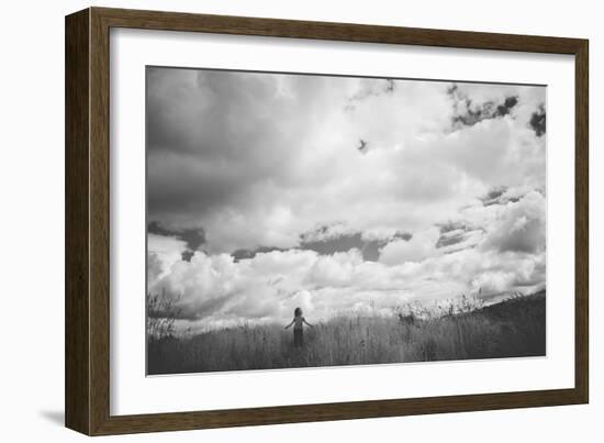 Young Girl Standing in a Field with Clouds-Clive Nolan-Framed Photographic Print