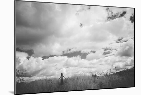 Young Girl Standing in a Field with Clouds-Clive Nolan-Mounted Photographic Print