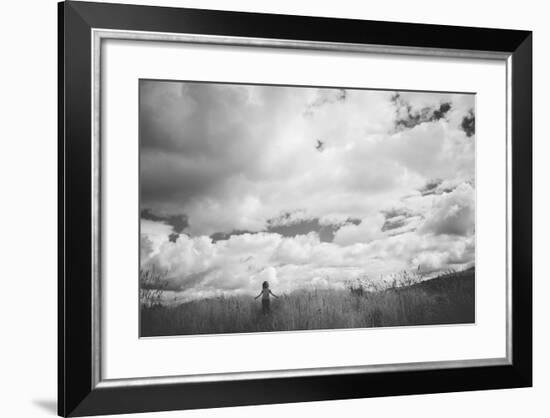 Young Girl Standing in a Field with Clouds-Clive Nolan-Framed Photographic Print