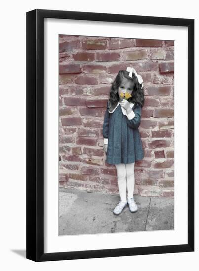Young Girl Standing in Front of a Stone Wall Smelling a Flower.-Nora Hernandez-Framed Giclee Print