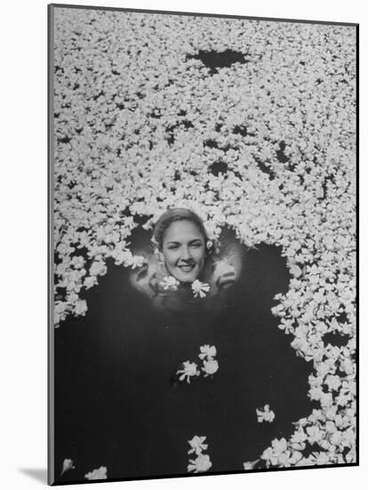 Young Girl Swimming in Pool Covered with Gardenia Blossoms-Eliot Elisofon-Mounted Photographic Print